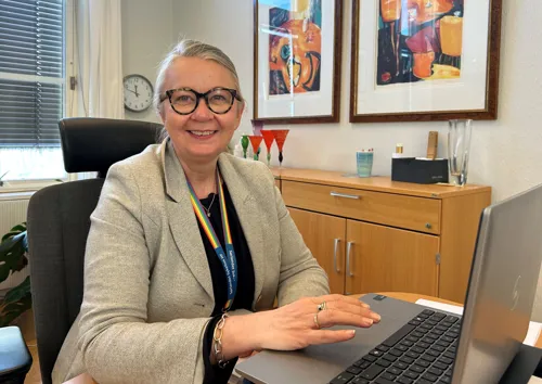 En person som sitter ved et skrivebord med en bærbar datamaskin