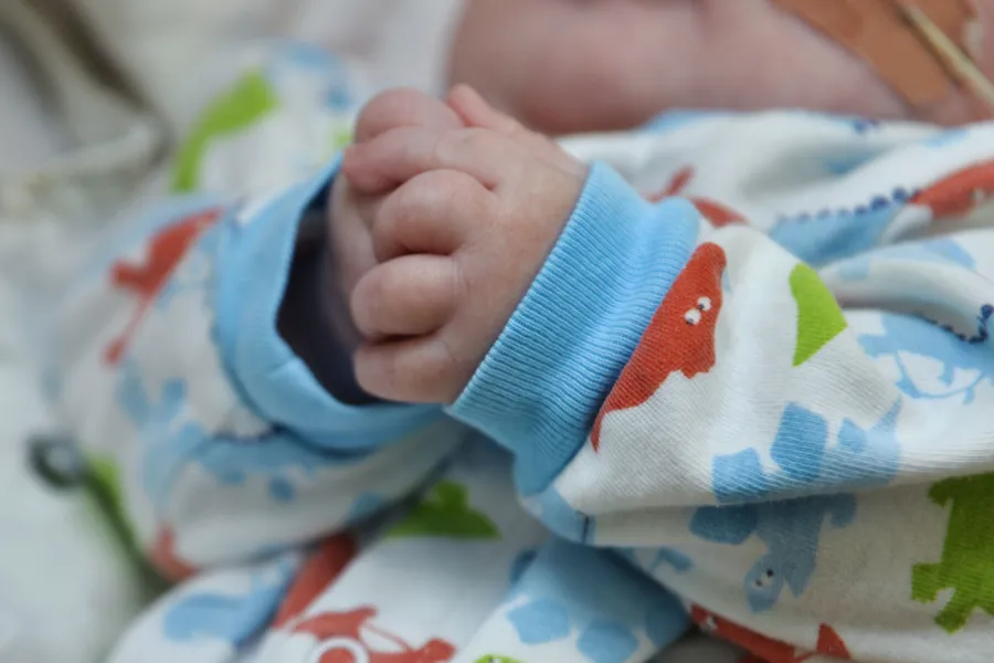 En babyhånd på et teppe