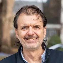 En mann som smiler til kameraet